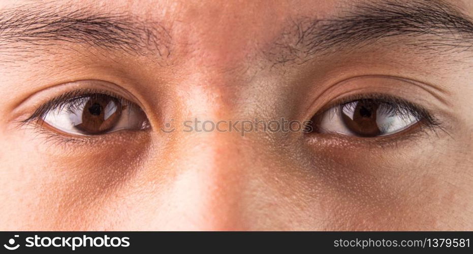 Close-up of Asian teenage guy brown eye with looking straight to the target. Healthy life concept.