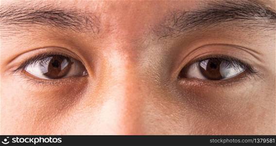 Close-up of Asian teenage guy brown eye with looking straight to the target. Healthy life concept.