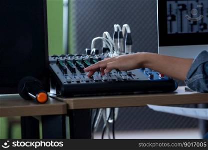 Close-up of Asian woman vocalist Wearing Headphones recording a song front of control desk equipment for sound recording  in a professional studio