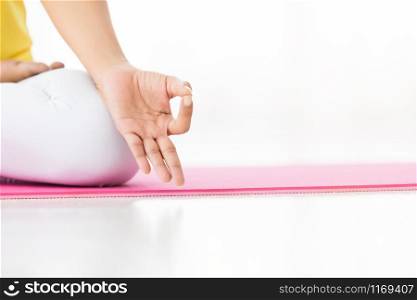 Close-up of Asian women workout practicing yoga training put in yellow dress and practice meditation wellness lifestyle and health fitness concept in a gym,Copy space