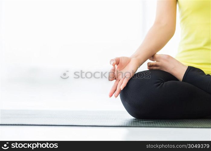 Close-up of Asian women workout practicing yoga training put in yellow dress and practice meditation wellness lifestyle and health fitness concept in a gym