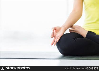 Close-up of Asian women workout practicing yoga training put in yellow dress and practice meditation wellness lifestyle and health fitness concept in a gym