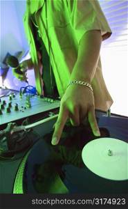 Close-up of Asian young adult male DJ&acute;s hand spinning vinyl record.