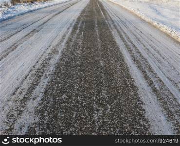 Close-up of asphalt road background covered with snow
