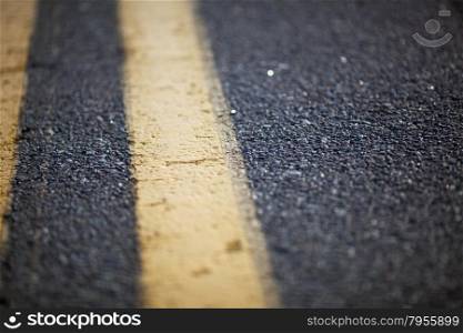 Close up of asphalt road with yellow marking