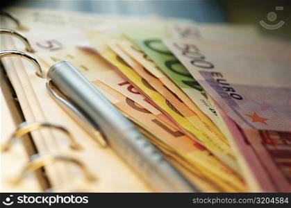 Close-up of assorted Euro banknotes on a diary
