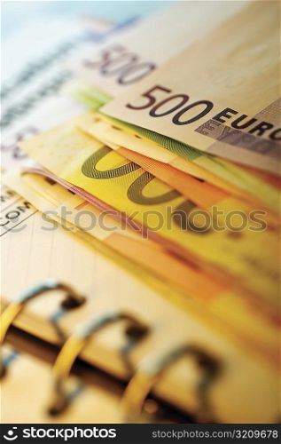 Close-up of assorted Euro banknotes on a diary