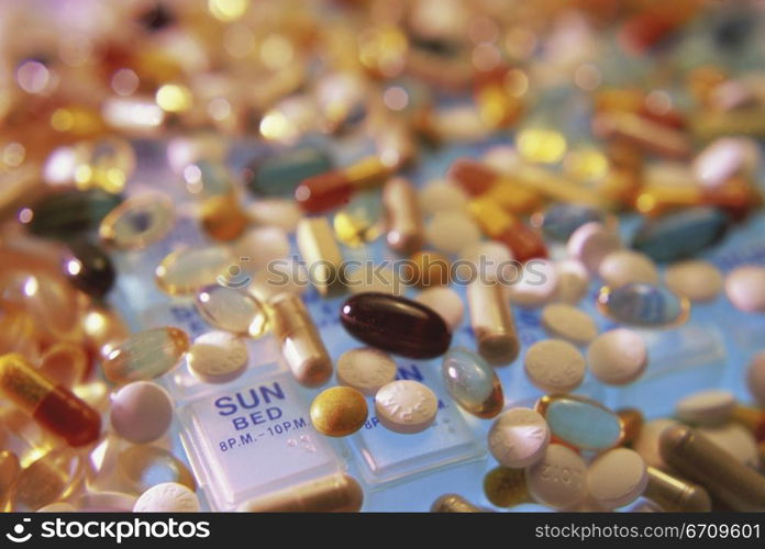 Close-up of assorted pills and capsules on a pill box