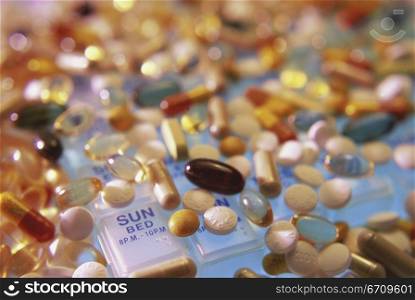 Close-up of assorted pills and capsules on a pill box