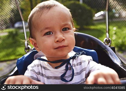 Close up of baby boy on park swing