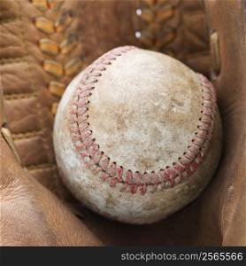 Close up of baseball resting in baseball glove.