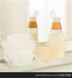 Close-up of bathroom body care products on shelf mirror reflection