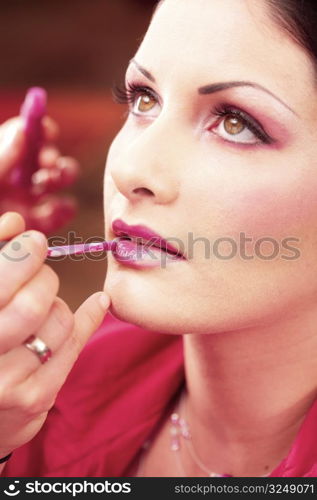 Close up of beautician creating makeup for a young women in the beauty parlour.