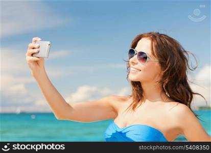 close up of beautiful woman on the beach with phone