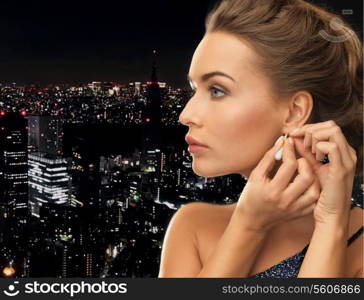 close up of beautiful woman wearing shiny diamond earrings