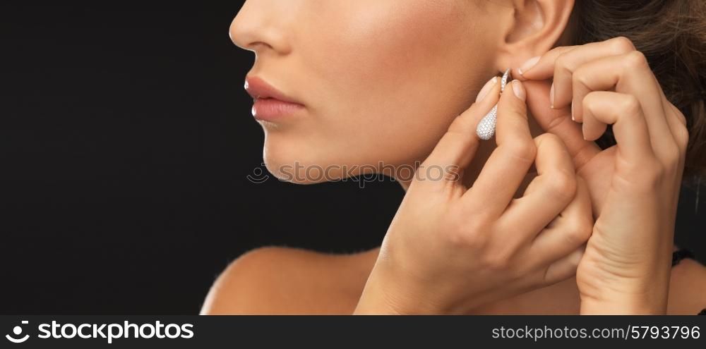 close up of beautiful woman wearing shiny diamond earrings