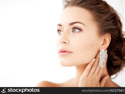 close up of beautiful woman wearing shiny diamond earrings. woman wearing shiny diamond earrings