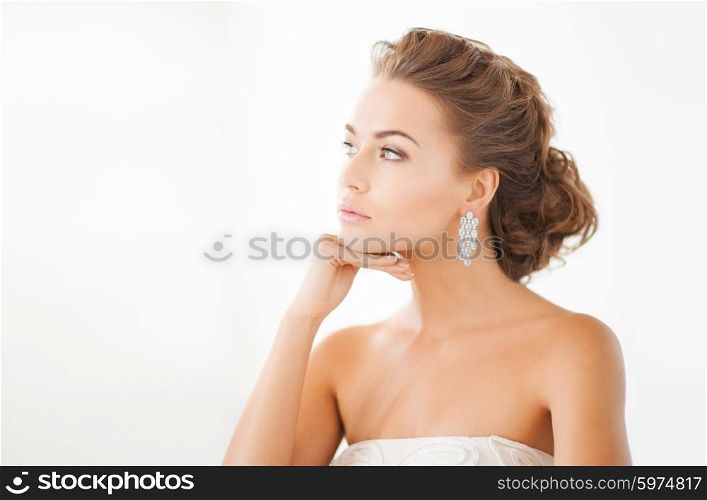 close up of beautiful woman wearing shiny diamond earrings. woman wearing shiny diamond earrings