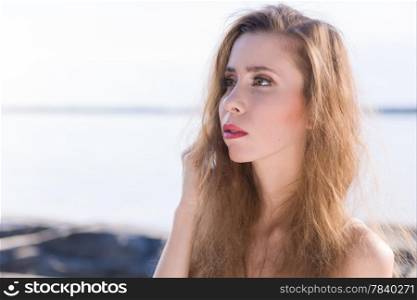 Close up of beautiful young woman, scandinavian shore and sea on background