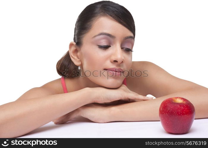 Close-up of beautiful young woman staring at fully ripped apple