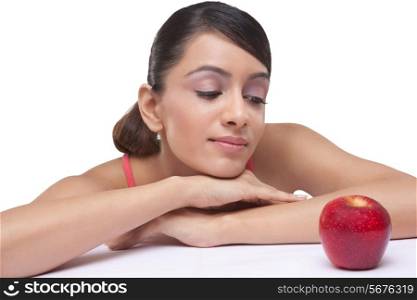 Close-up of beautiful young woman staring at fully ripped apple