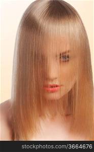 close up of beauty portrait of a young and cute blond girl with hairstyle with the hair covering her face