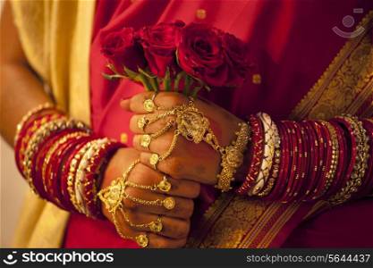 Close-up of Bengali brides hands holding roses