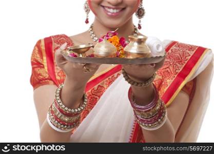 Close-up of Bengali woman&rsquo;s hands holding puja thali