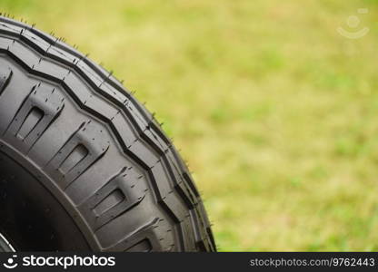 Close up of black gum tire from big car vehicle machine with tread.. Black tire from big machine