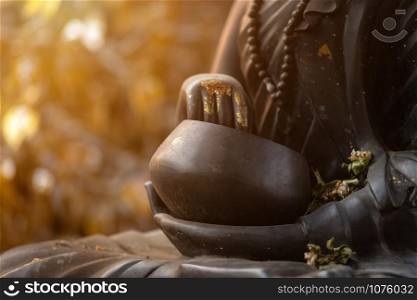 Close up of black monks alms bowl buddha statue in the Wat Lok Moli temple in Chiang Mai, Thailand.