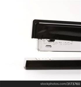 Close up of black stapler on white background.
