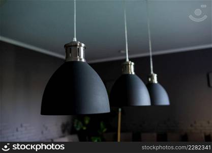 Close up of black stylish lamps hang over billiard table. Leisure activity interior design elements. selective focus.. Close up of black stylish lamps hang over billiard table. Leisure activity interior design elements. selective focus