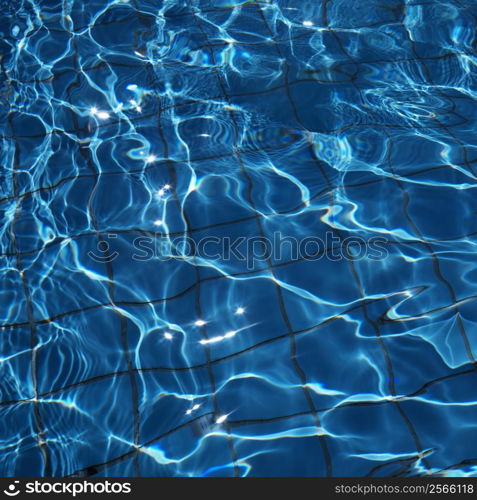 Close-up of blue reflective rippling water with grid pattern in bottom of pool.