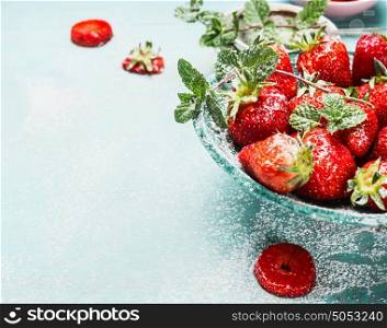 Close up of bowl with Strawberries on light blue rustic background, front view