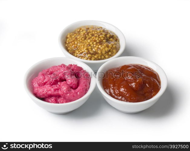 close up of bowls of tomato ketchup and mustard and barbecue sauce with clipping path