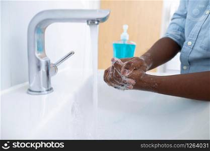 Close Up Of Boy Washing Hands With Soap At Home To Prevent Infection