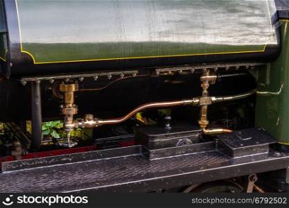 Close up of brass pipes on outside of steam locomotive.
