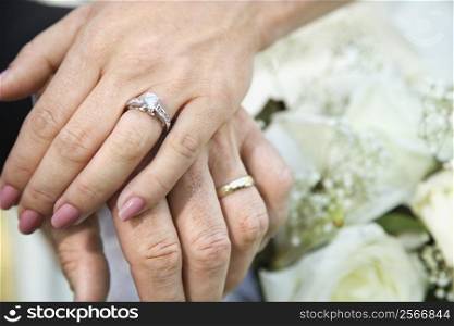 Close-up of bride and groom&acute;s hands overlapping.