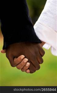 Close up of bride and groom holding hands on wedding day