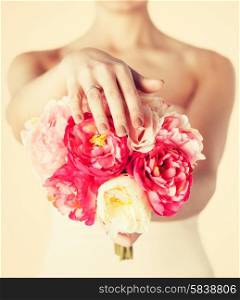 close up of bride with bouquet of flowers and wedding ring