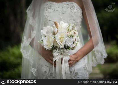 Close up of bride with wedding bridal flower in hands.