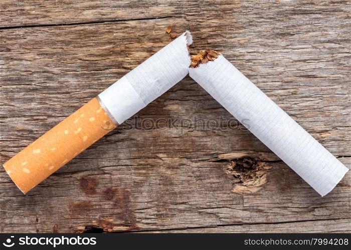 Close-up of broken cigarette on wooden background (Quit smoking today).