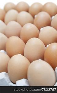 Close-up of brown eggs arranged in carton