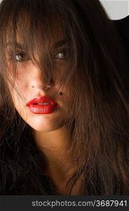 close up of brunette with red lips and long hair looking in camera