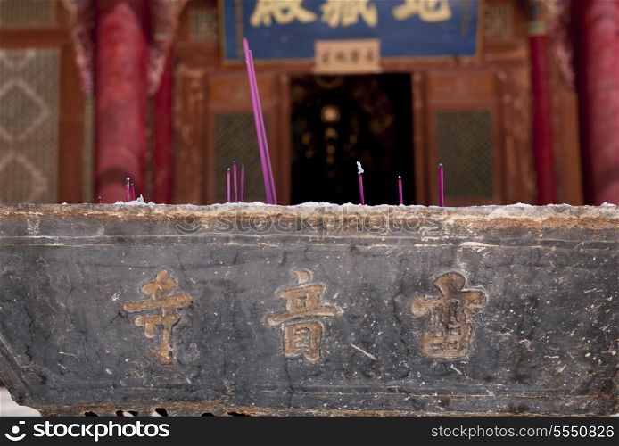 Close-up of burning incense sticks in a temple, China
