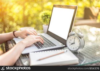 Close-up of Business female working with laptop, coffee, clock, smart phone, and notebook on office outdoor.