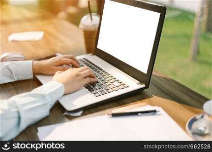 Close-up of business female working with laptop make a note document and smartphone in coffee shop like the background.
