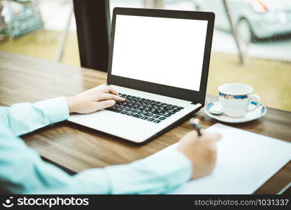 Close-up of business female working with laptop make a note in coffee shop like the background.