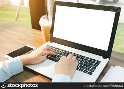 Close-up of business female working with laptop with blank white screen make a note document and smartphone in coffee shop like the background.