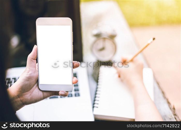 Close-up of Business female working with smartphone,laptop,clock and notebook on office outdoor.